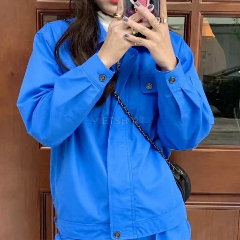 Cô gái mặc áo đồng phục bảo hộ lao động màu xanh lam đang chụp ảnh selfie, thần thái tự tin